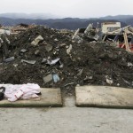 The body of a boy victim is covered by a blanket at a village destroyed by earthquake and tsunami in Rikuzentakata