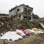 The bodies of victims are covered by blankets at a village destroyed by earthquake and tsunami in Rikuzentakata