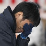 A survivor weeps as he looks at a board showing names of other survivors at a shelter in a village ruined by an 8.9 magnitude earthquake and tsunami in Rikuzentakata