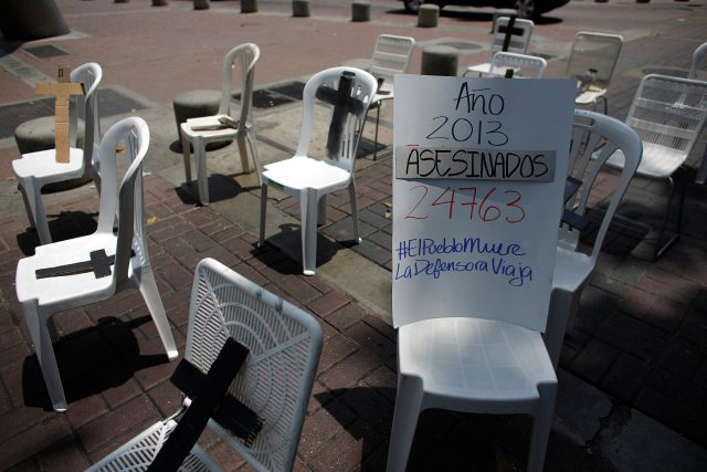 Placard showing the number of victims of violence during 2013, is seen along black crosses during an anti-government protest in Caracas