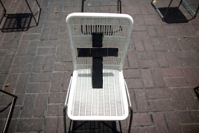 Black cross is placed on a white chair, representing a victim who died from violence, during a anti-government demonstration in Caracas
