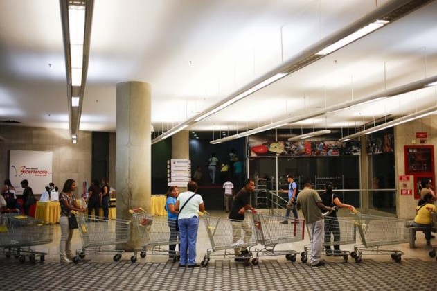 Unas personas realizan una cola para comprar en un supermercado estatal Bicentenario en Caracas