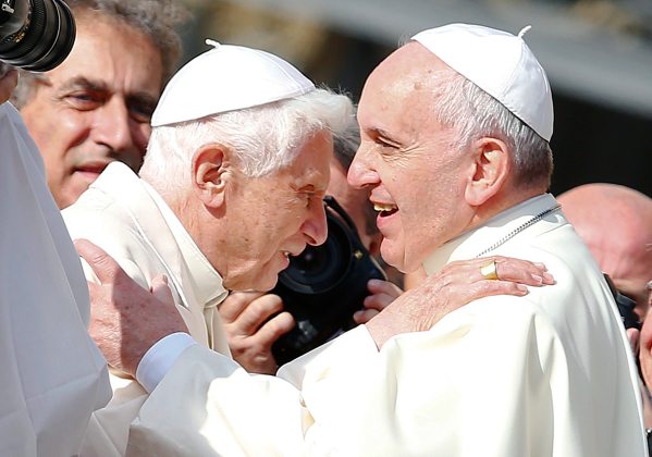 Pope Francis greets Emeritus Pope Benedict XVI before a mass in Saint Peter's square at the Vatican