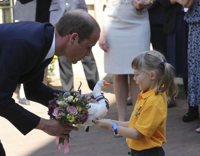 Príncipe Guillermo (i), recibe un cisne de juguete de manos de una niña a su llegada a la inauguración de un edificio universitario en Oxford.EFE