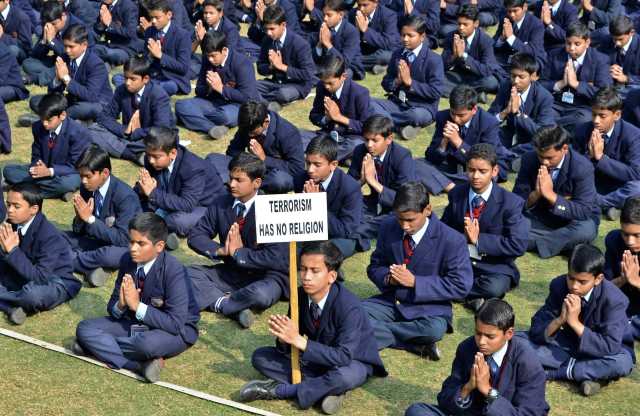 Schoolchildren take part in a prayer for victims of the Taliban attack on the Army Public School in Peshawar, in the northern Indian city of Mathura