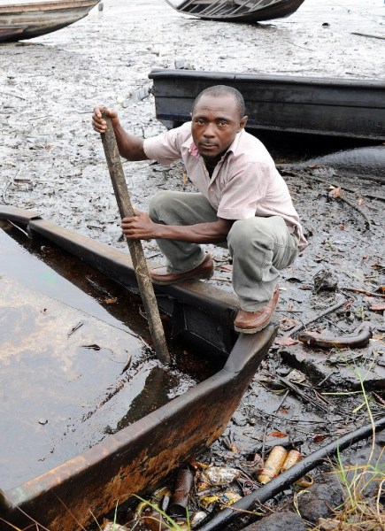 Foto: un indígena de Bodo, región de Ogoniland en el estado de Rivers, trata de separar el crudo del agua en un barco con un palo, a los cursos de agua Bodo contaminados por derrames de petróleo atribuidos a fallas en el equipo Shell / AFP
