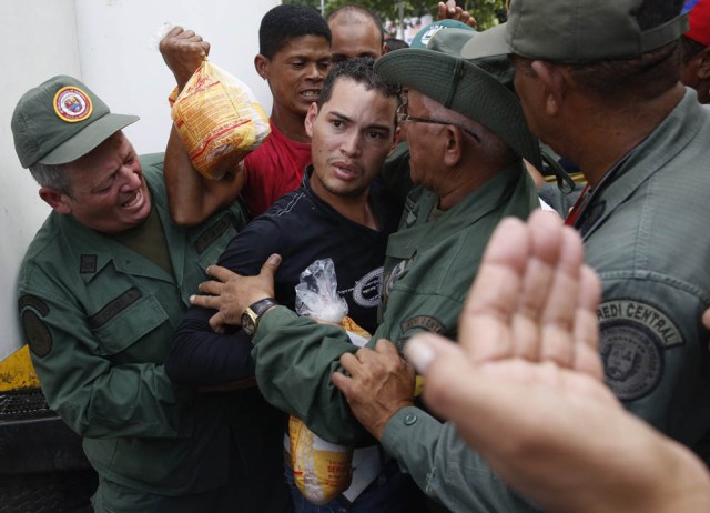 People argue with Venezuelan soldiers as they try to buy chickens at a Mega-Mercal, a subsidized state-run street market, in Caracas