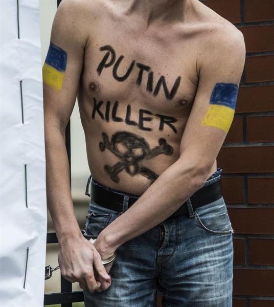 Foto: Un activista proucraniano, con la inscripción "Putin asesino" pintada en el torso, se encadena a la embajada rusa en Praga (República Checa) hoy, miércoles 25 de febrero de 2015. Un grupo de activistas ha protestado para exigir la liberación de la piloto ucraniana Nadiya Savchenko que permanece presa en Rusia. EFE
