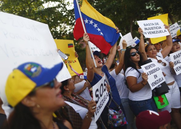 Venezuelan residents in Panama yell slogans and hold signs during a protest against Venezuela's President Nicolas Maduro ahead of his arrival for the Summit of the Americas, in Panama City