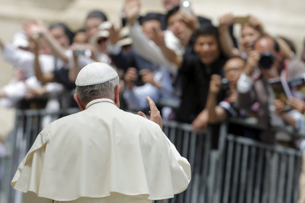 Pope Francis waves as he leaves after the weekly audience at the Vatican