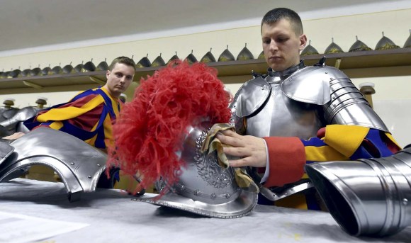 New Vatican Swiss guards polish their uniforms prior to a swearing-in ceremony at the Vatican