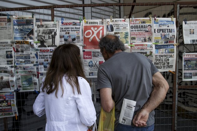 People read newspapers on a street in Athens