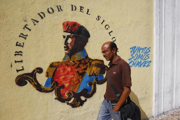 Imagen de archivo de un hombre pasando junto a un grafiti alusivo a la figura del ex presidente venezolano Hugo Chávez en el aniversario de su muerte en Caracas