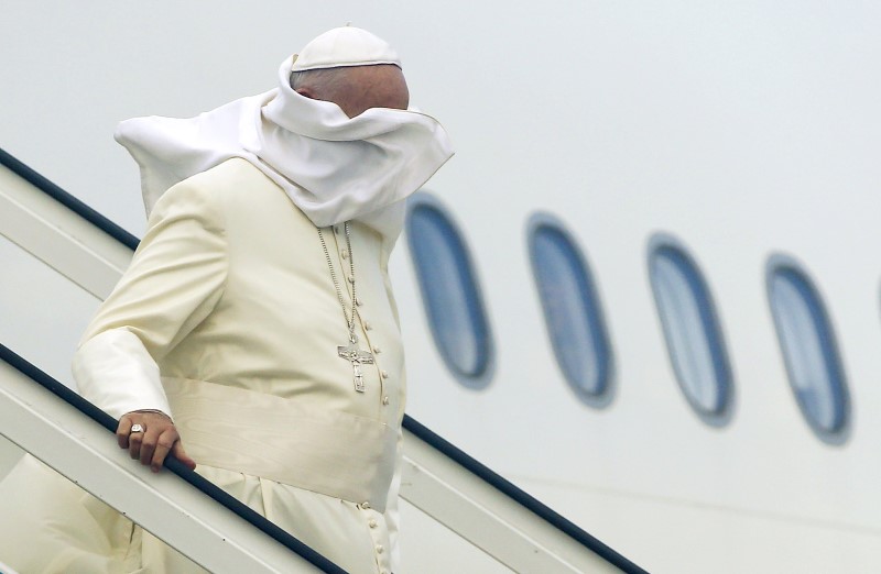 El viento vuela la vestimenta del Papa Francisco mientras está bajando del avión tras aterrizar en el aeropuerto de La Habana, 19 de septiembre de 2015. REUTERS/Tony Gentile