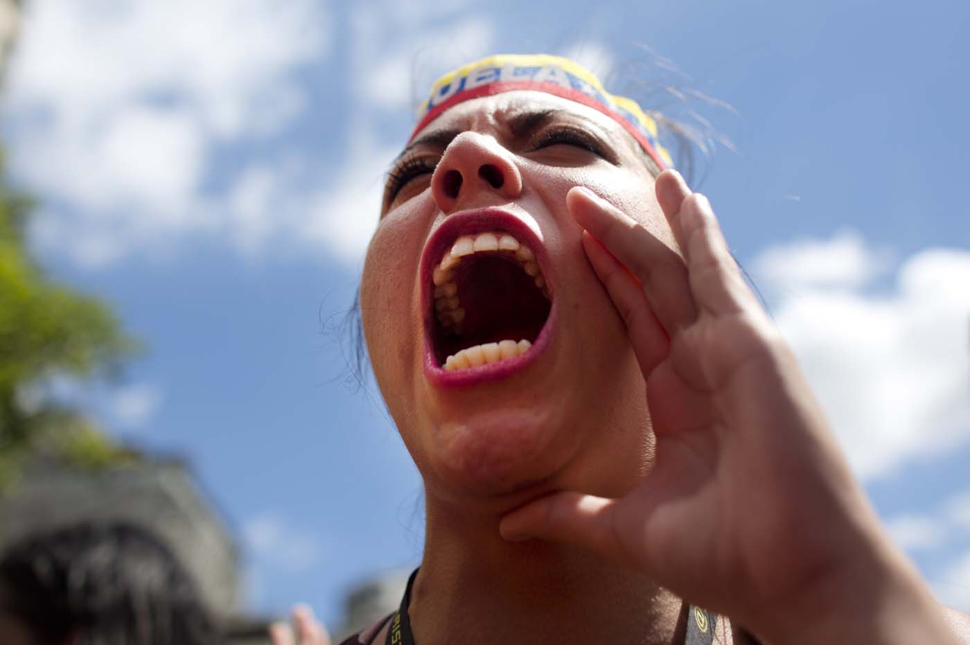Una estudiante grita consignas contra el gobierno, mientras participa en una manifestación de apoyo a las elecciones legislativas en Venezuela, en Caracas, el sábado 21 de noviembre de 2015. Más de dos decenas de partidos compiten en las elecciones del 6 de diciembre, las más duras en 16 años para el partido gobernante. (Foto AP/Ariana Cubillos)