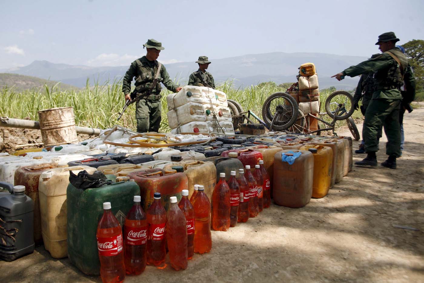 Venezuelan soldiers collect containers with gasoline abandoned by smugglers near the Colombian border in San Antonio, in the state of Tachira, February 17, 2016. REUTERS/Carlos Eduardo Ramirez. EDITORIAL USE ONLY. NO RESALES. NO ARCHIVE.