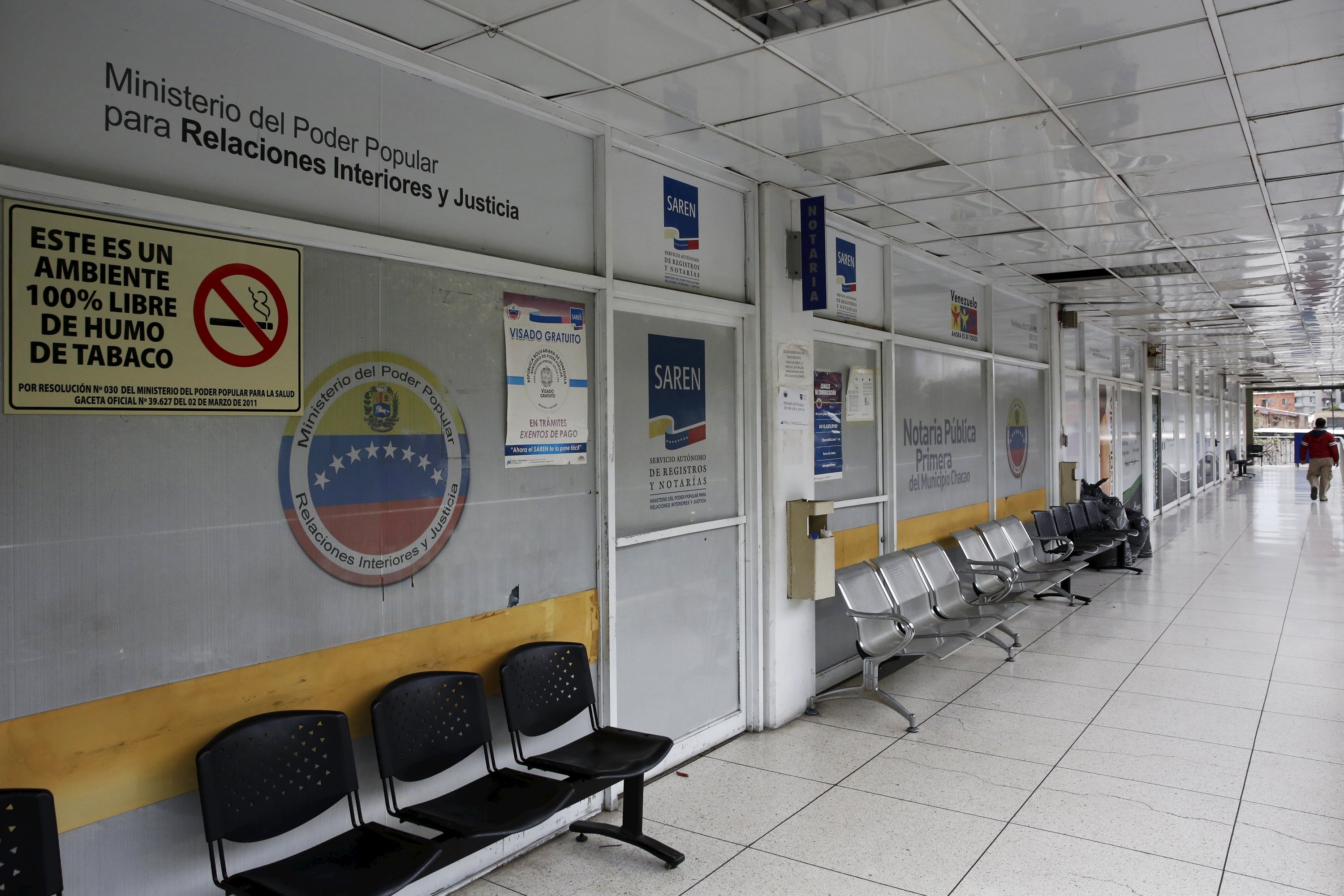 A man walks past a closed notary office in Caracas April 22, 2016. REUTERS/Carlos Garcia Rawlins