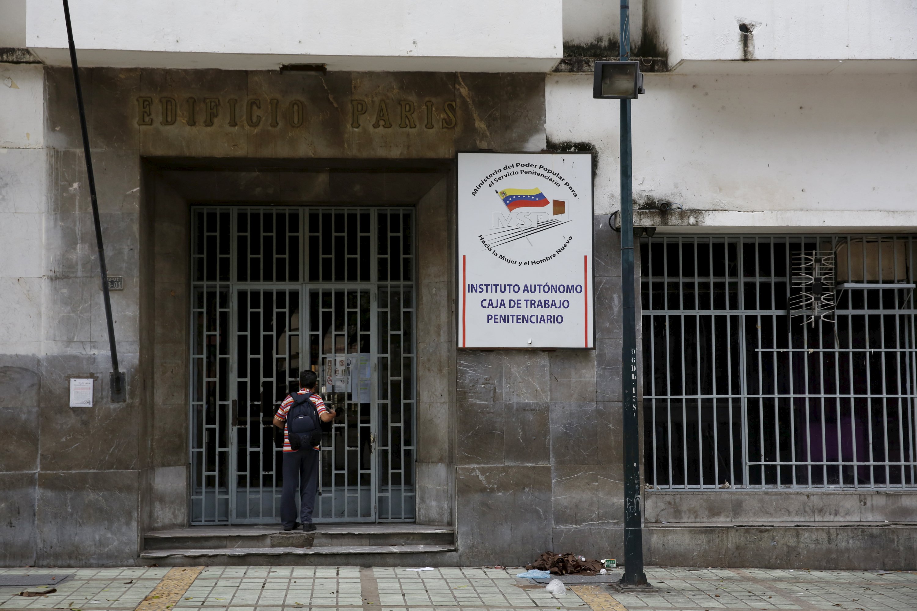 A man stands in front of a closed entrance of an office of the Prisons Ministry in Caracas, April 22, 2016. REUTERS/Carlos Garcia Rawlins