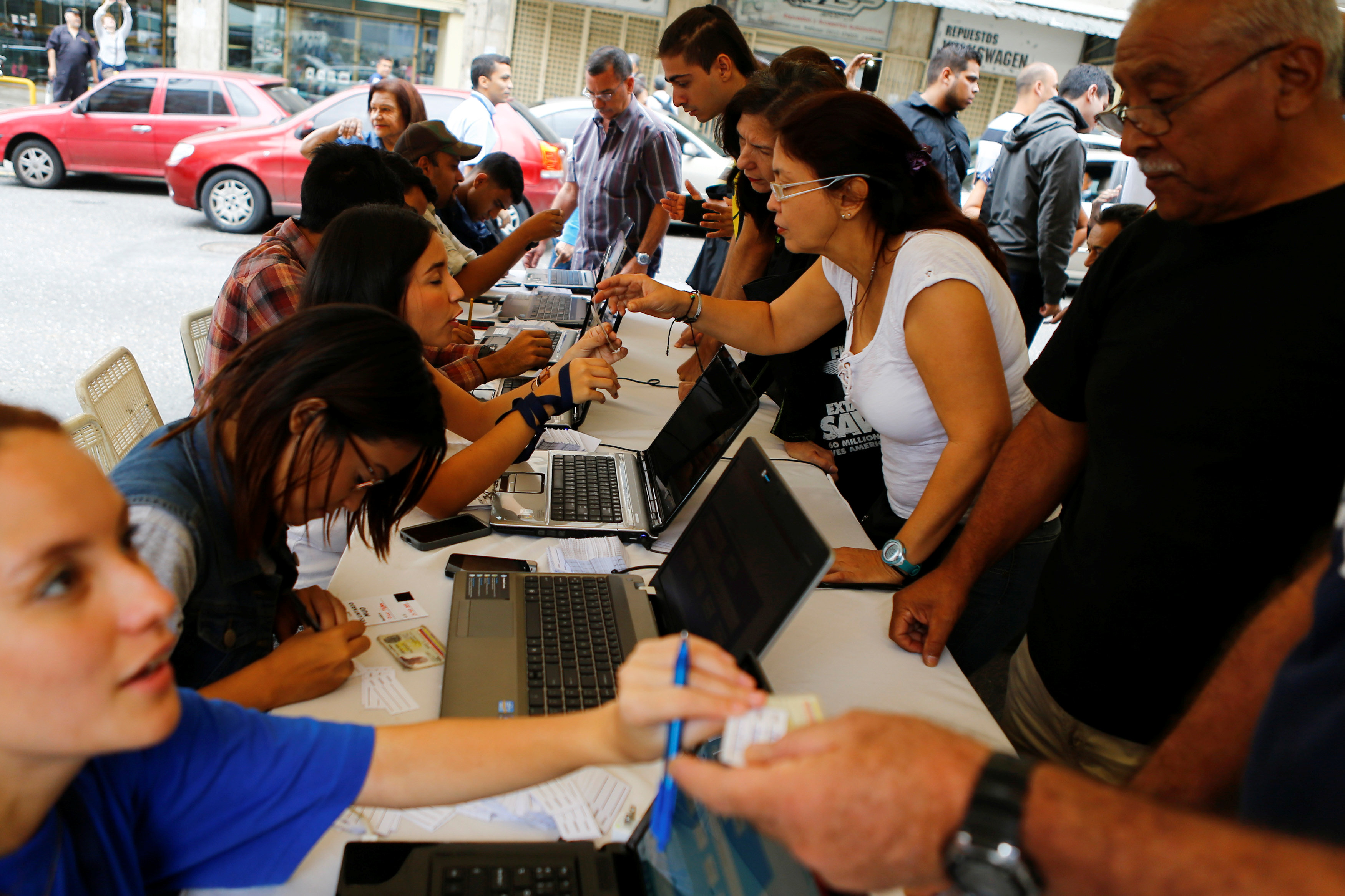 People take part in the verification process of Venezuela's coalition of opposition parties (MUD), outside a validation center during Venezuela’s National Electoral Council (CNE) second phase of verifying signatures for a recall referendum against President Nicolas Maduro in Caracas, Venezuela, June 20, 2016. REUTERS/Ivan Alvarado