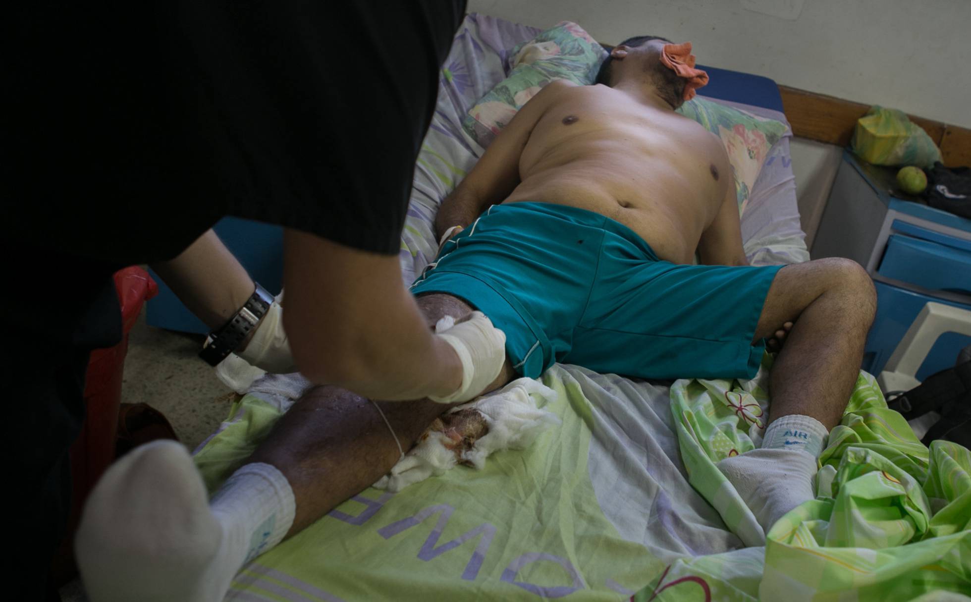 El médico de turno cura a un paciente en el Hospital del Periferico de Coche en Caracas. FABIOLA FERRERO