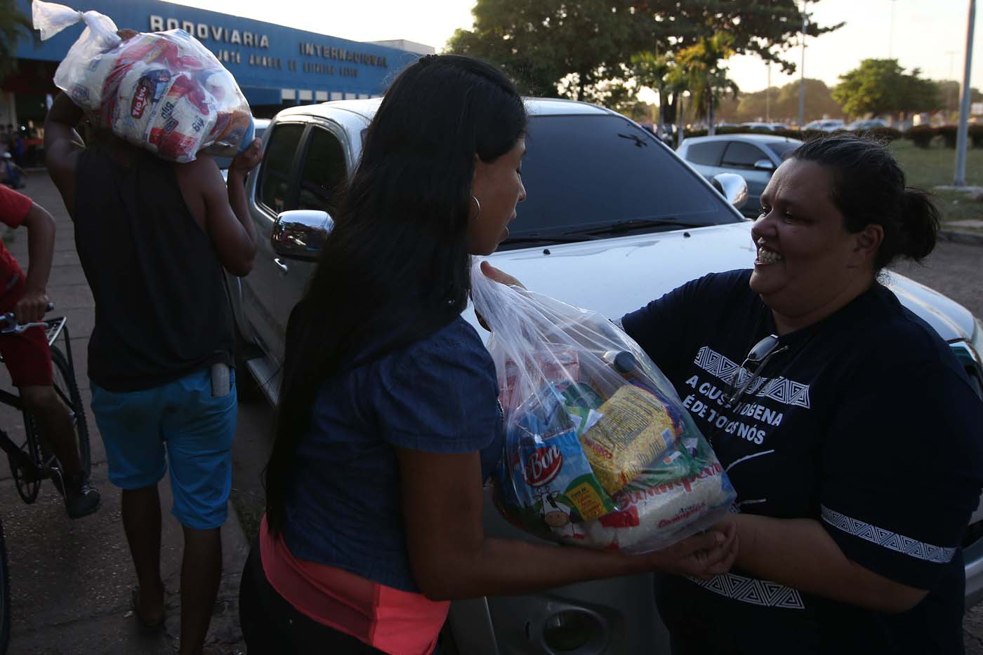 La coordinadora de la Comisión de Migración y Derechos Humanos del estado brasileño de Roraima, Telma Lage, entrega alimentos a inmigrantes venezolanos Foto: EFE / Marcelo Sayão