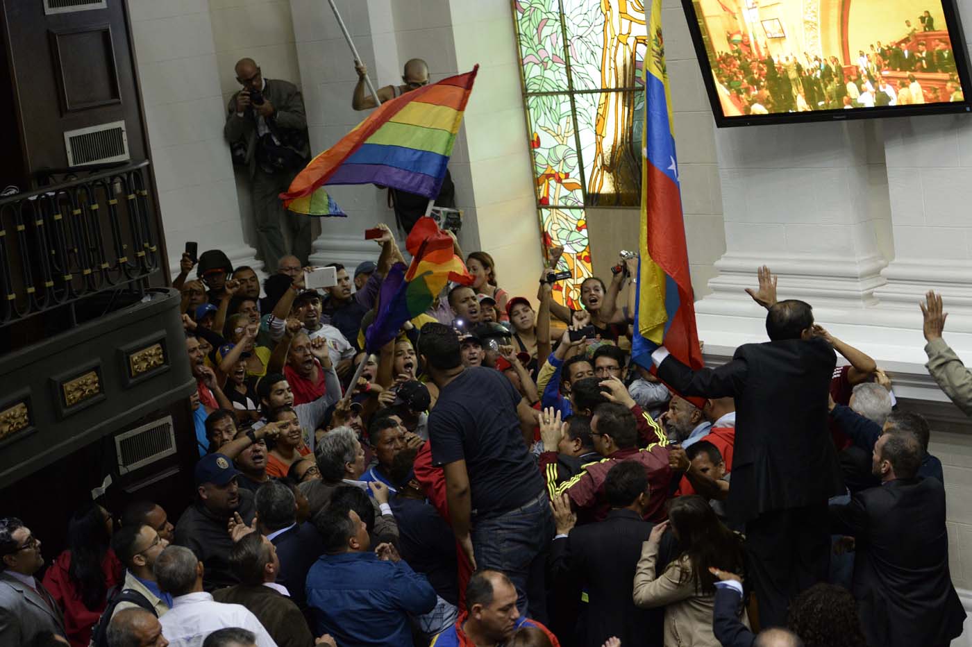 Supporters of Venezuelan President Nicolas Maduro force their way to the National Assembly during an extraoridinary session called by opposition leaders, in Caracas on October 23, 2016. The opposition Democratic Unity Movement (MUD) called a Parliamentary session to debate putting President Nicolas Maduro on trial to "restore democracy" in an emergency session that descended into chaos as supporters of the leftist leader briefly seized the chamber. / AFP PHOTO / FEDERICO PARRA