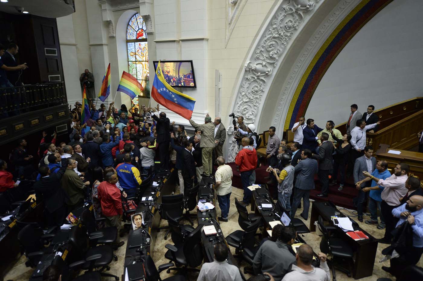 Supporters of Venezuelan President Nicolas Maduro force their way to the National Assembly during an extraordinary session called by opposition leaders, in Caracas on October 23, 2016. The opposition Democratic Unity Movement (MUD) called a Parliamentary session to debate putting President Nicolas Maduro on trial to "restore democracy" in an emergency session that descended into chaos as supporters of the leftist leader briefly seized the chamber. / AFP PHOTO / FEDERICO PARRA