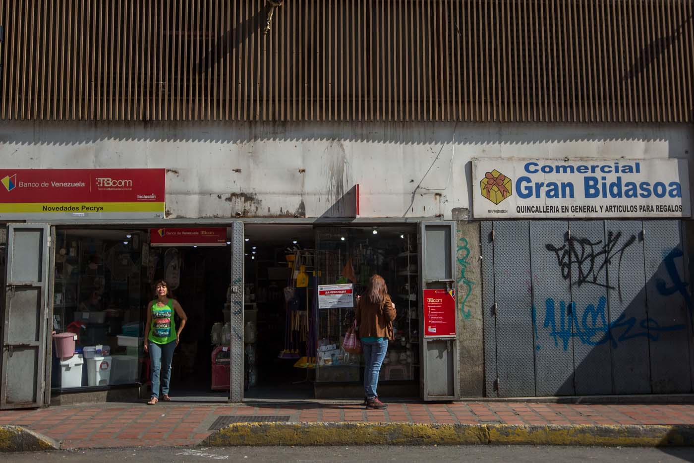 CAR01. CARACAS (VENEZUELA), 28/10/2016.- Un local comercial abierto y otro cerrado hoy, viernes 28 de octubre de 2016, en Caracas (Venezuela). El paro general de 12 horas convocado por la oposición venezolana se cumple a medias en el país pues tanto las entidades bancarias como algunos comercios y oficinas abrieron sus puertas, sin embargo, las principales vías se mostraron con mucho menos tráfico que el que se observa en un día laboral normal. EFE/MIGUEL GUTIÈRREZ