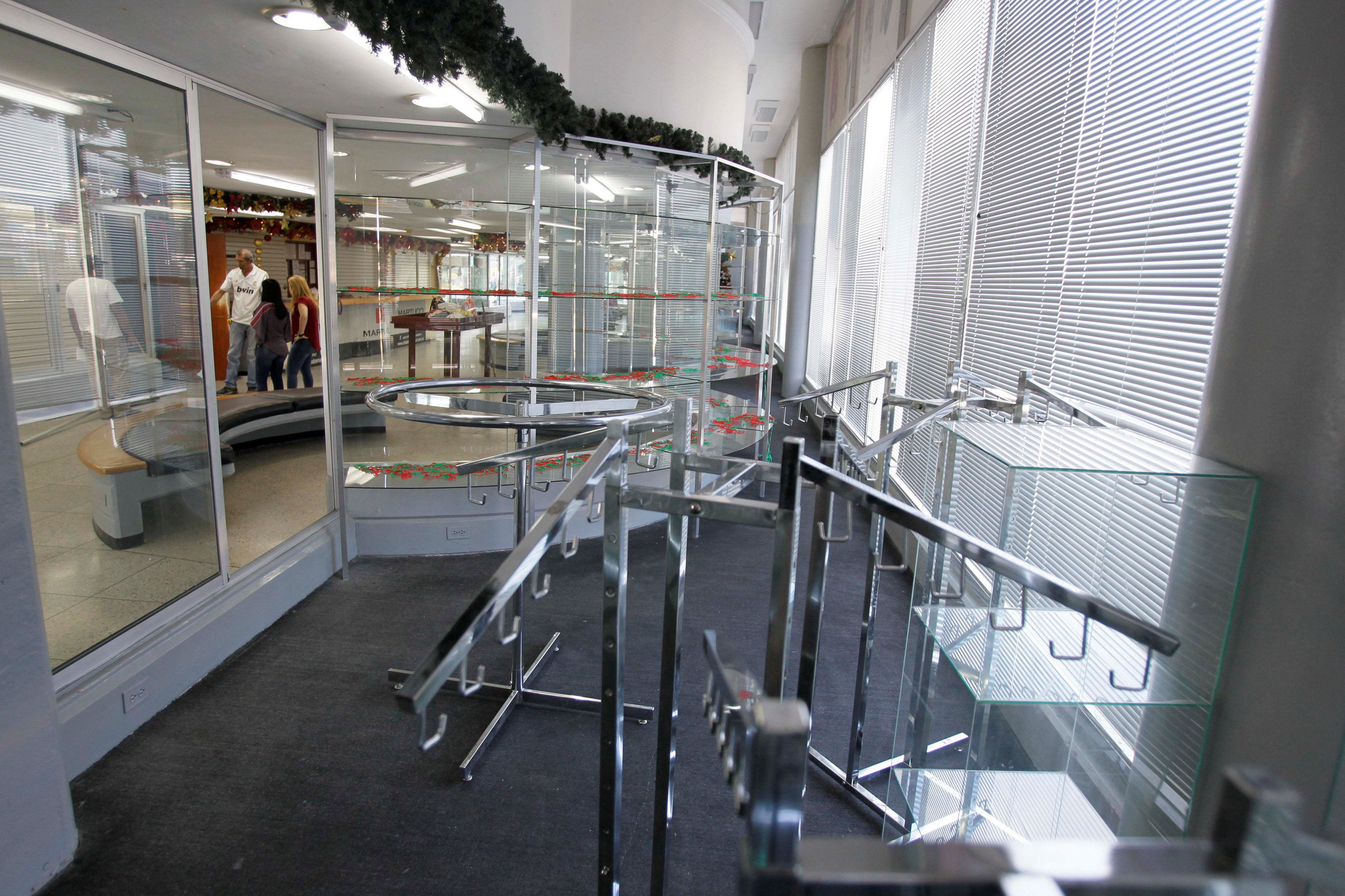 Broken showcases and empty shelves are seen after a shoe shop was looted in Maracaibo