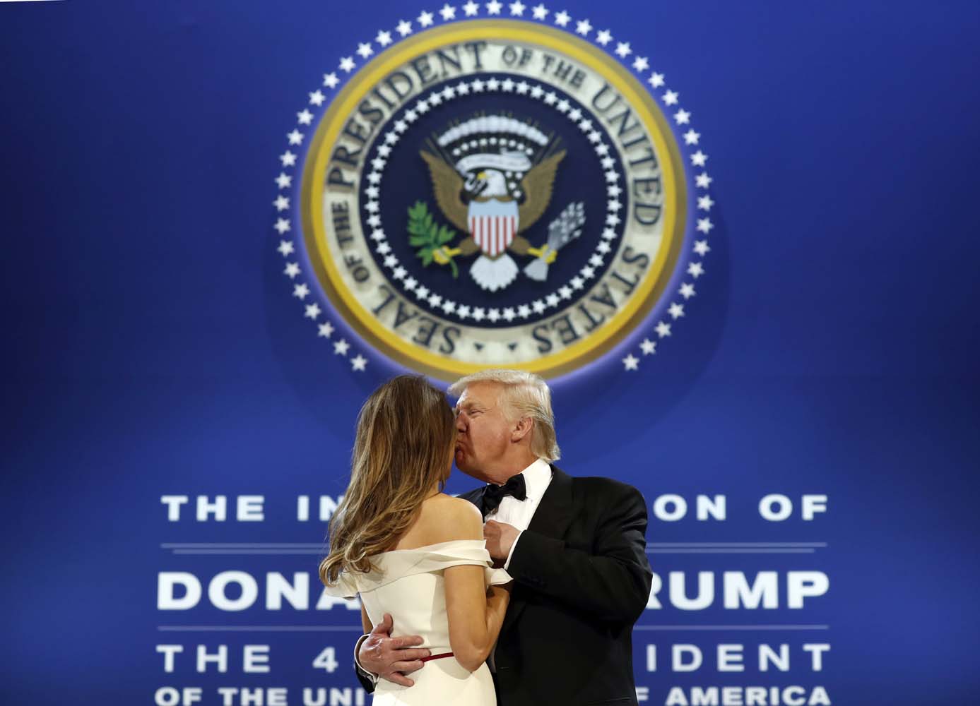 President Donald Trump kisses first lady Melania Trump as they dance at the The Salute To Our Armed Services Inaugural Ball in Washington, Friday, Jan. 20, 2017. (AP Photo/Alex Brandon)