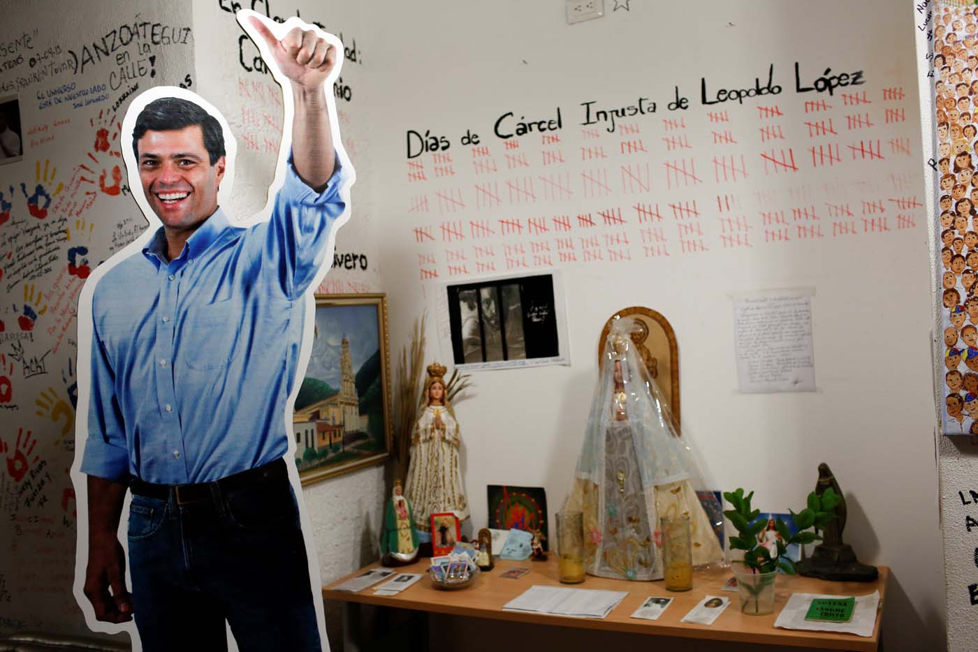 A cardboard cut-out of the jailed opposition leader Leopoldo Lopez is seen next to a religious altar, at the office of the party Popular Will (Voluntad Popular) in Caracas, Venezuela January 18, 2017. Picture taken January 18, 2017. REUTERS/Carlos Garcia Rawlins