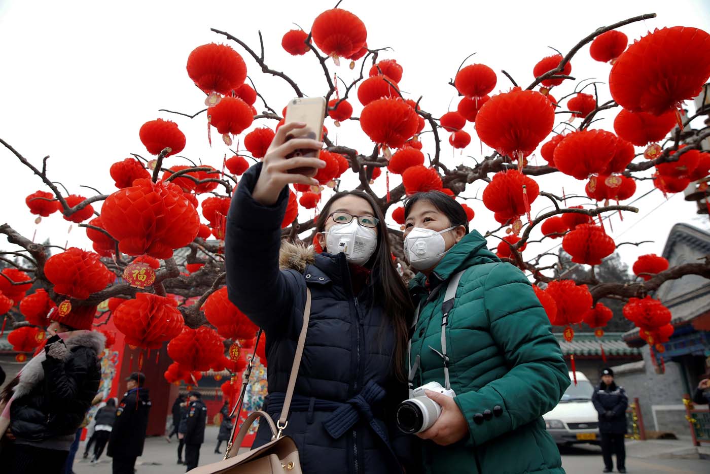 Visitors wearing face masks against pollution take pictures of themselves at the temple fair at Ditan Park (the Temple of Earth) as the Lunar New Year of the Rooster is celebrated, in Beijing, China January 28, 2017. REUTERS/Damir Sagolj