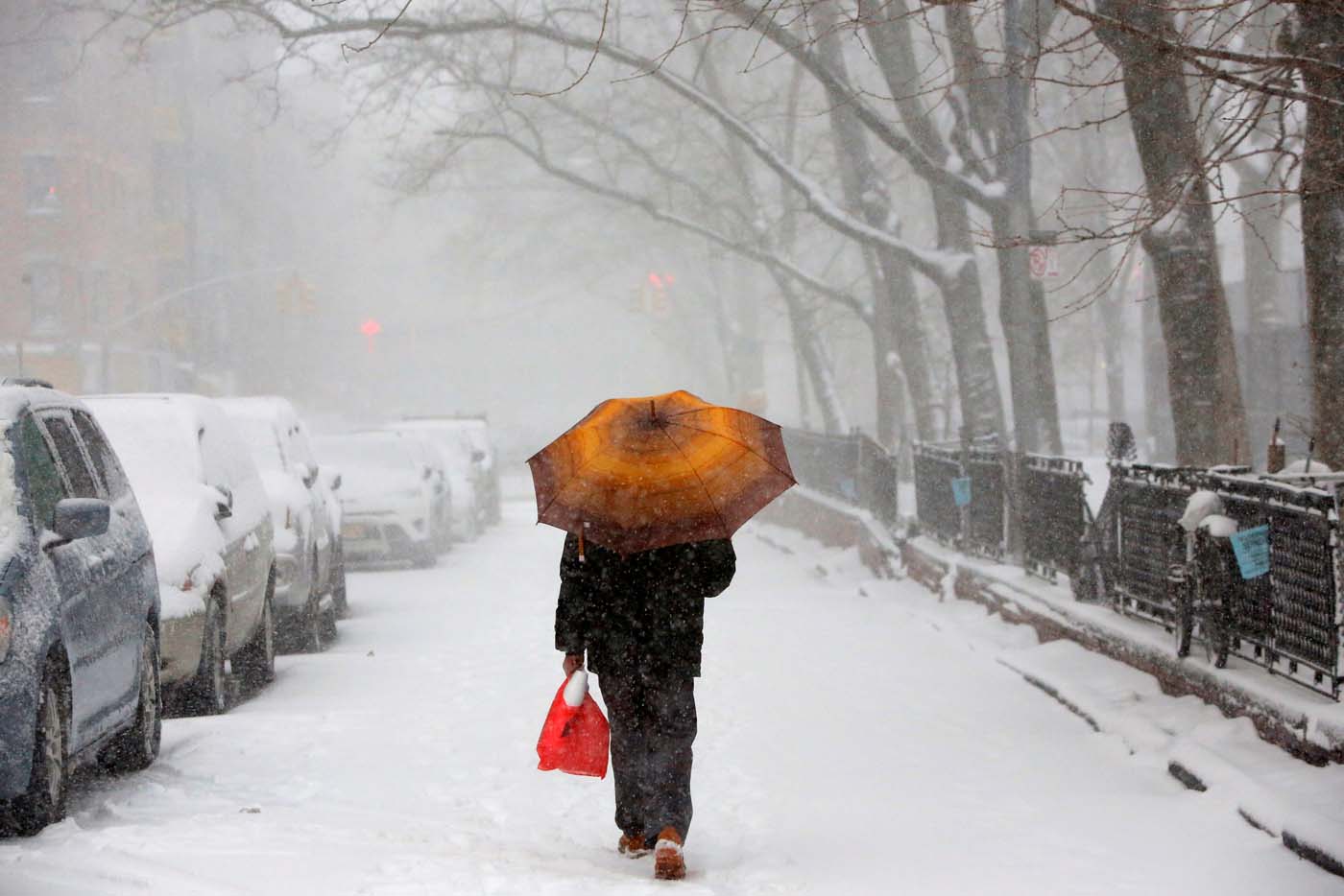 A man walks through the Lower East Side as snow falls in Manhattan, New York, U.S. February 9, 2017. REUTERS/Andrew Kelly