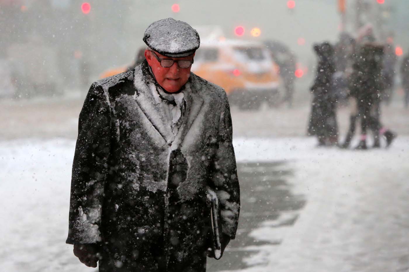 A man walks in Times Square as snow falls in Manhattan, New York, U.S. February 9, 2017. REUTERS/Andrew Kelly
