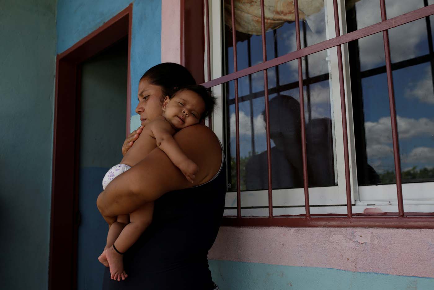 Jennifer Vivas, mother of Eliannys Vivas, who died from diphtheria, carries her baby at the front porch of her home in Pariaguan, Venezuela January 26, 2017. Picture taken January 26, 2017. REUTERS/Marco Bello
