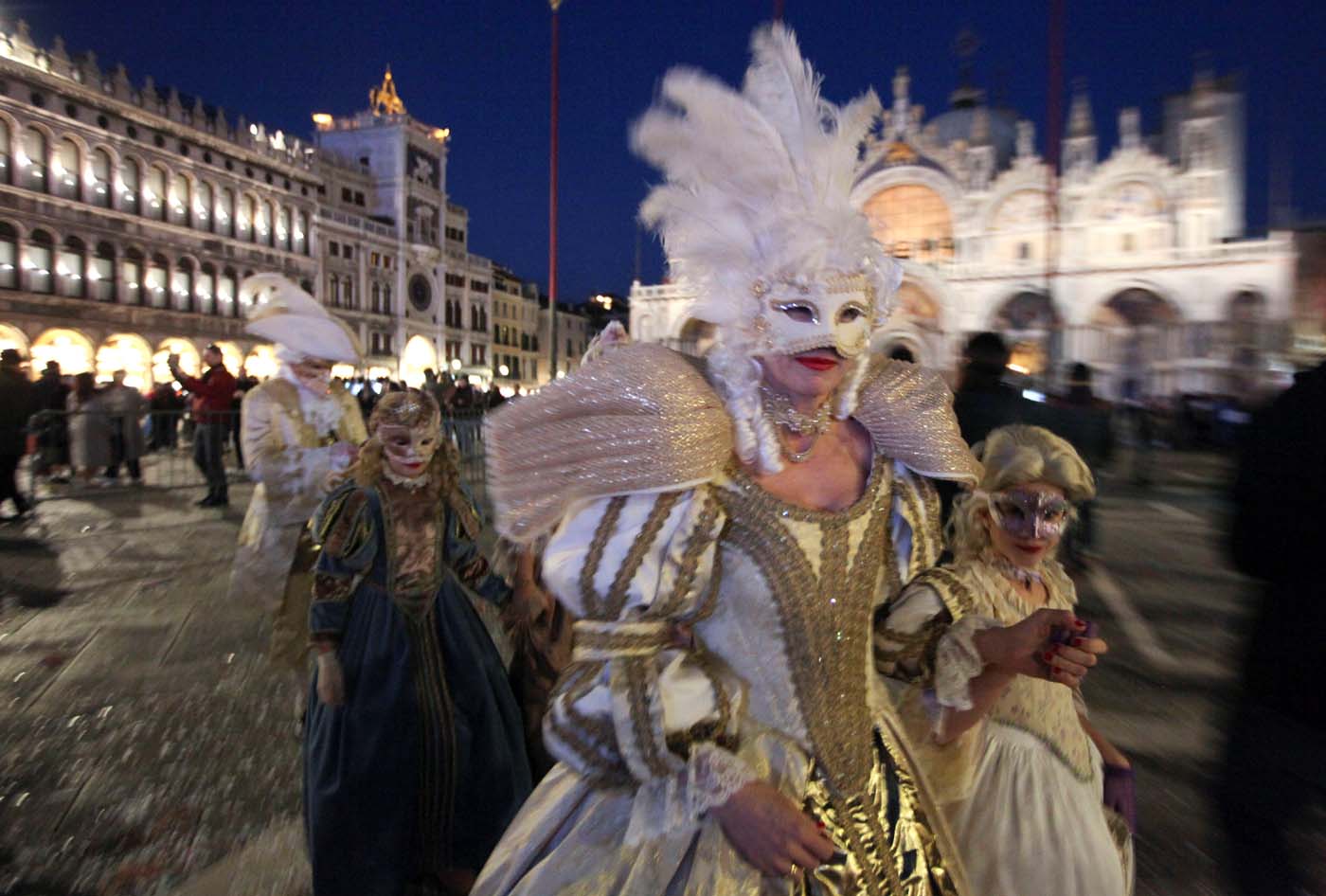 Masked revellers walk on St. Mark's Square during the Venice Carnival in Venice, Italy February 18, 2017. REUTERS/Fabrizio Bensch