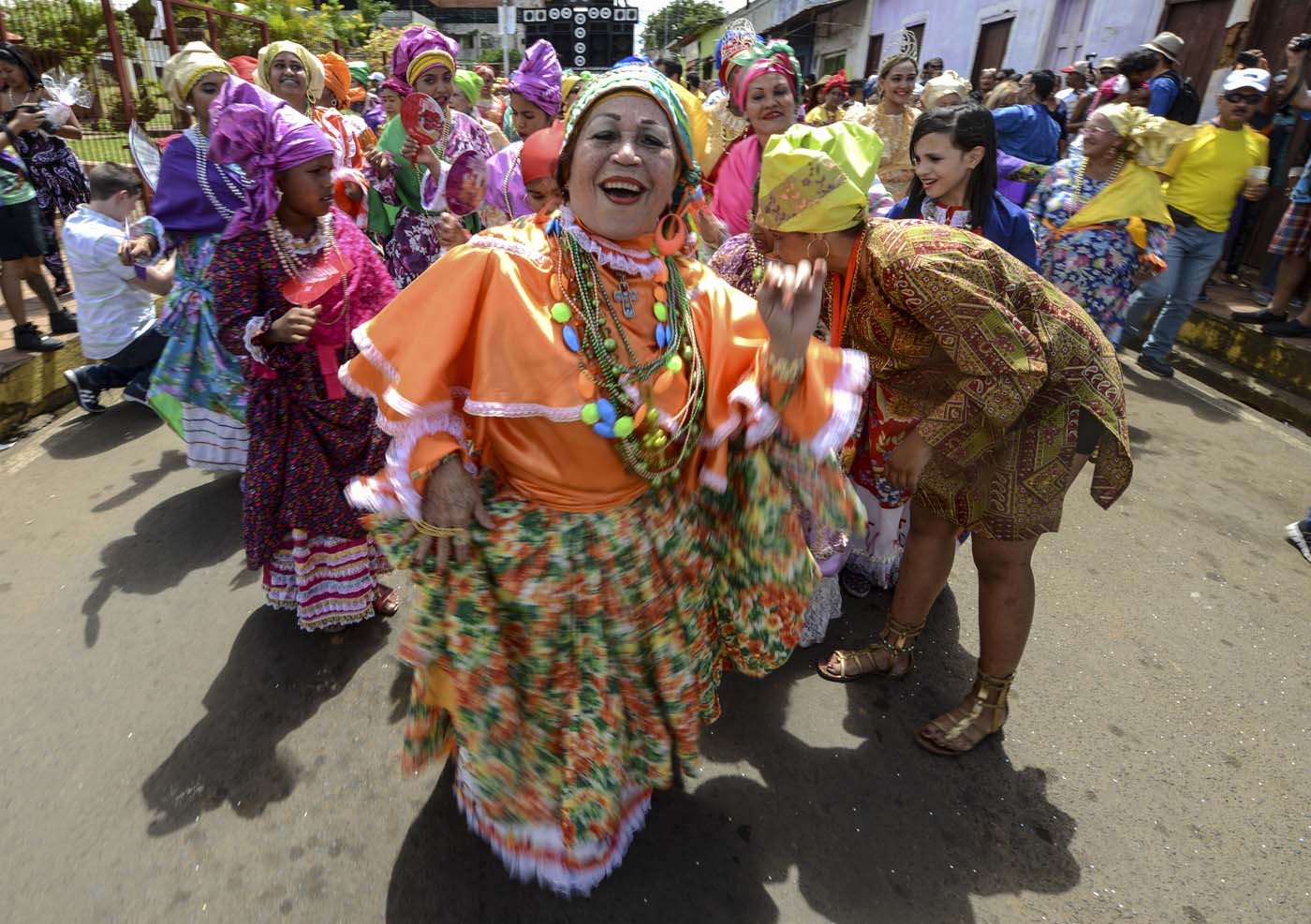 Women dressed as "madamas" dance as they take part in a parade during the Carnival in El Callao, Bolivar state, Venezuela on February 26, 2017.  El Callao's carnival was recently named Unesco's Intangible Cultural Heritage of Humanity and is led by the madamas, the pillars of Callaoense identity representing Antillean matrons considered the communicators of values, who dance and wear colourful dresses. / AFP PHOTO / JUAN BARRETO