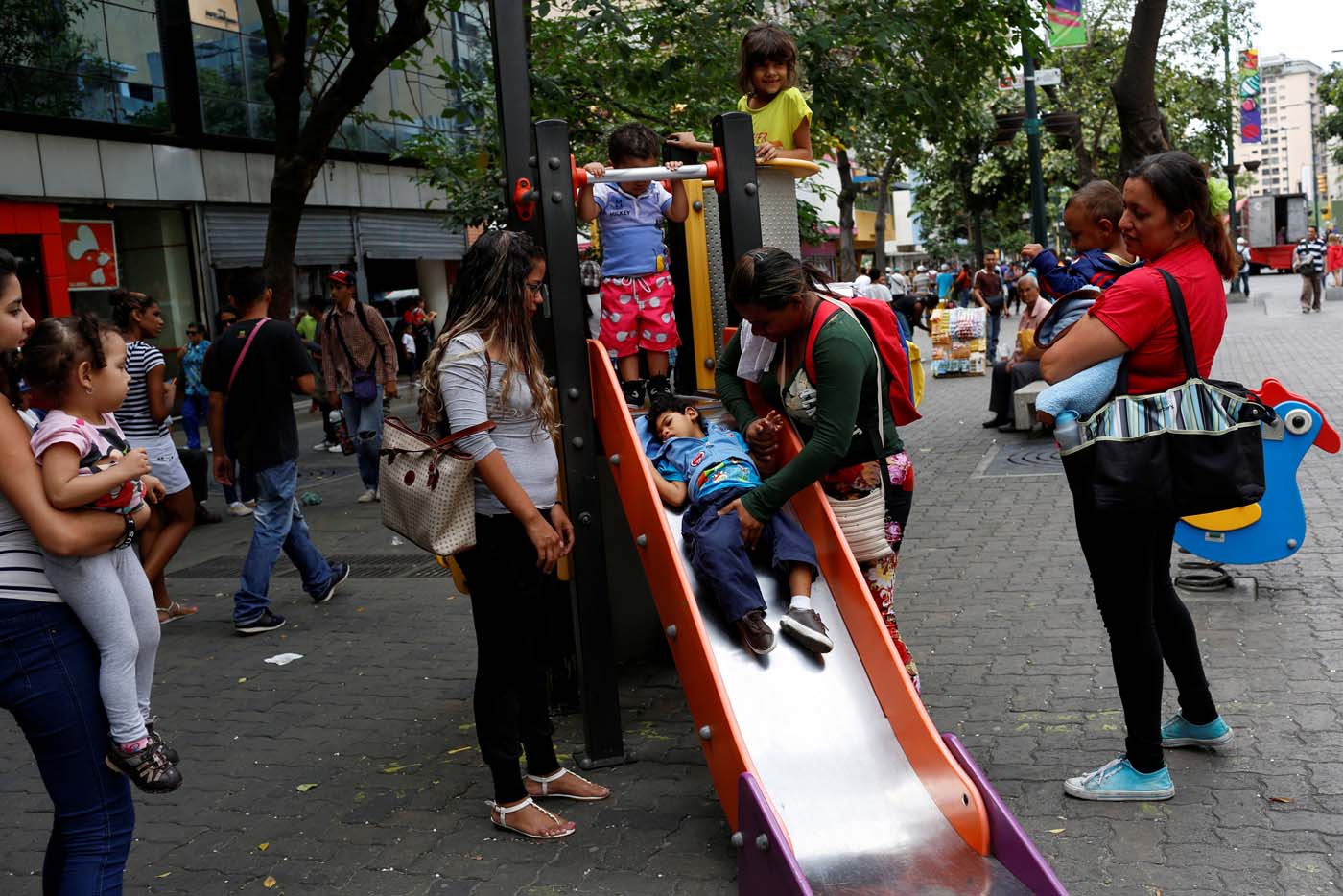Tatiana Rocha (C), plays with her son Kaleth Heredia, 2, a neurological patient being treated with anticonvulsants, at a park in Caracas, Venezuela February 10, 2017. REUTERS/Carlos Garcia Rawlins   SEARCH "EPILEPSY CARACAS" FOR THIS STORY. SEARCH "WIDER IMAGE" FOR ALL STORIES.