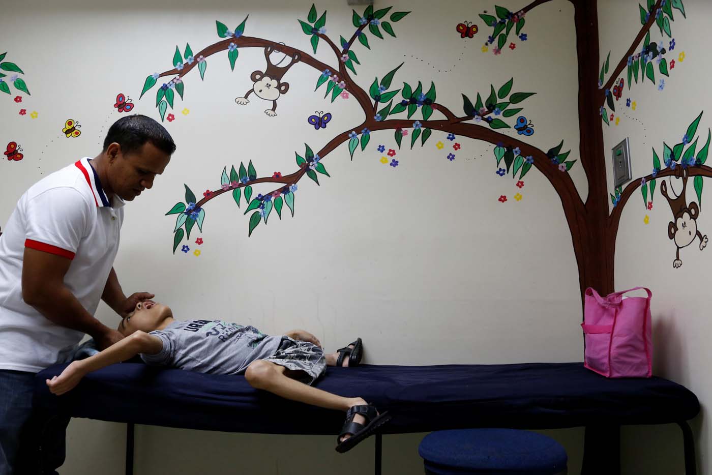 Miguel Anton (L) comforts his son Jose Gregorio Anton, 11, a neurological patient being treated with anticonvulsants, after a blood test at a clinic in La Guaira, Venezuela February 20, 2017. REUTERS/Carlos Garcia Rawlins    SEARCH "EPILEPSY CARACAS" FOR THIS STORY. SEARCH "WIDER IMAGE" FOR ALL STORIES.