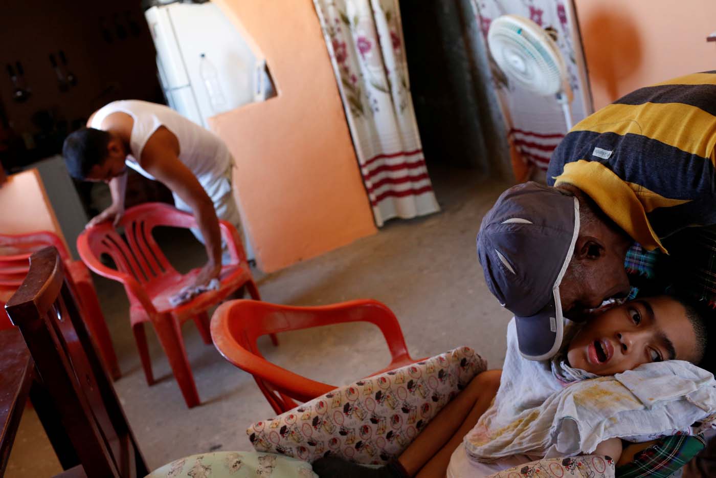 Jose Gregorio Anton (R), 11, a neurological patient being treated with anticonvulsants, is kissed by a neighbour at his house in La Guaira, Venezuela February 15, 2017. REUTERS/Carlos Garcia Rawlins   SEARCH "EPILEPSY CARACAS" FOR THIS STORY. SEARCH "WIDER IMAGE" FOR ALL STORIES.