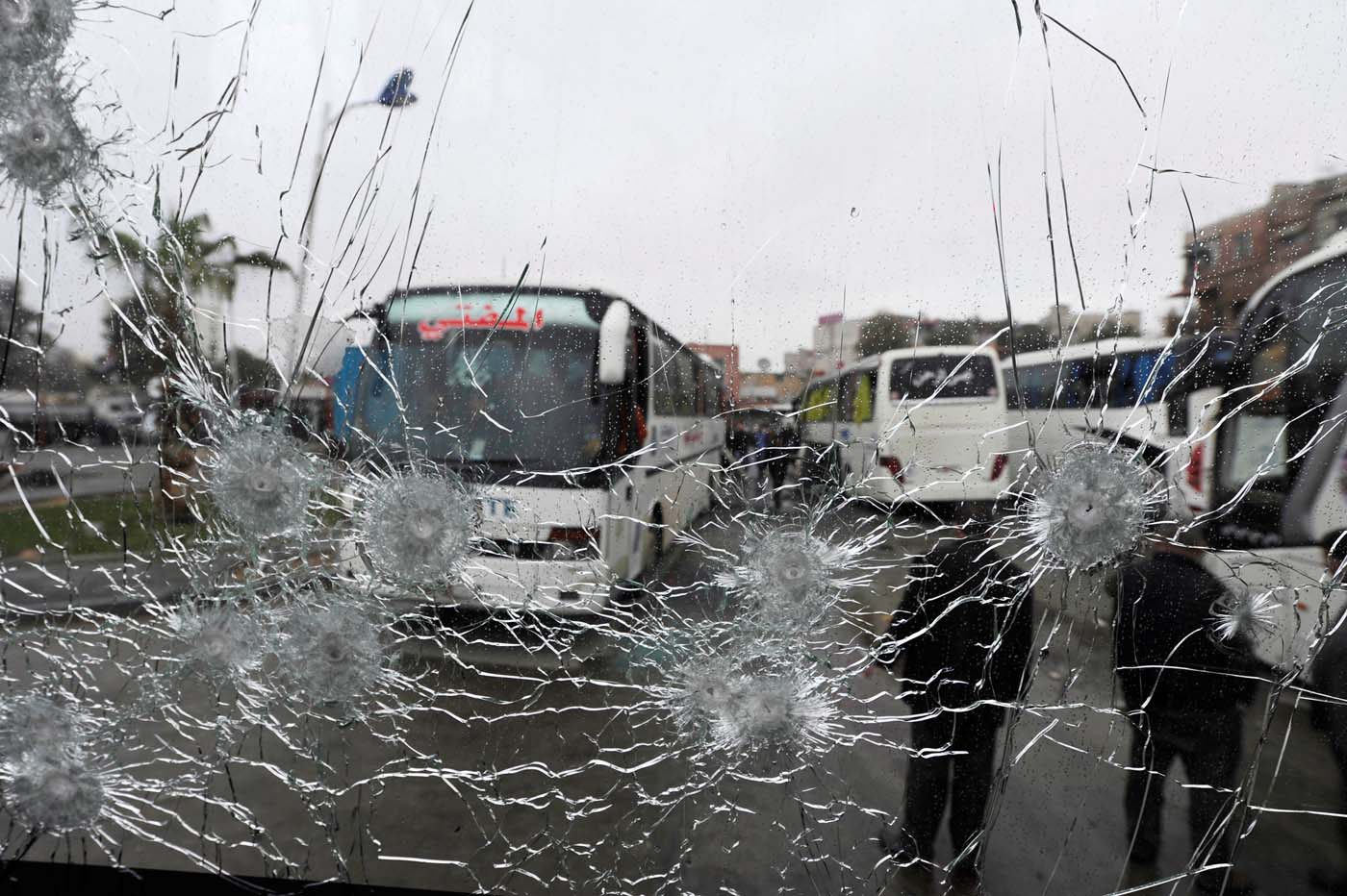 People are seen though a shattered glass window of a bus at the site of an attack by two suicide bombers in Damascus, Syria March 11, 2017. REUTERS/Omar Sanadiki TPX IMAGES OF THE DAY