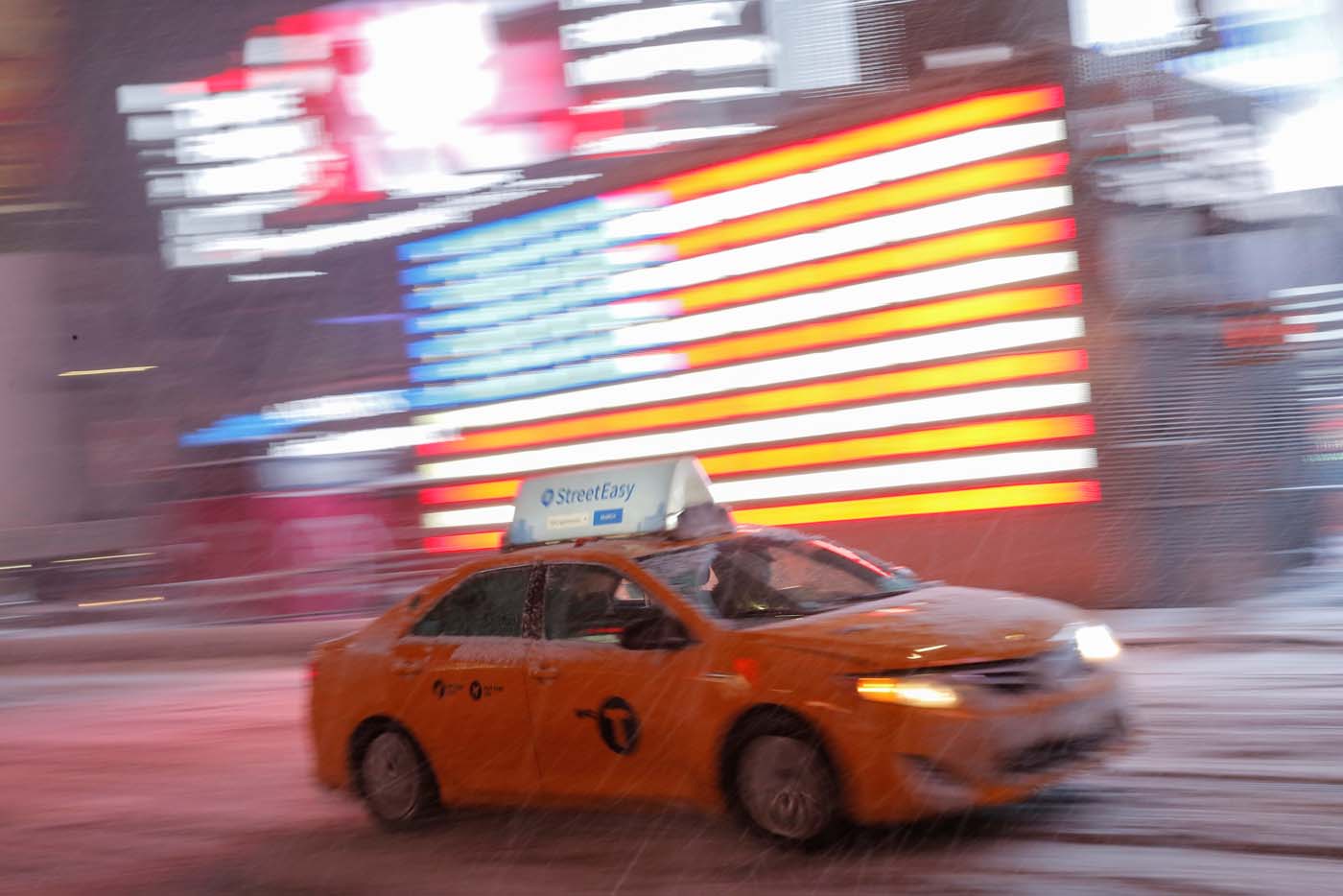 A taxi cab drives through Times Square as snow falls in Manhattan, New York, U.S., March 14, 2017. REUTERS/Andrew Kelly