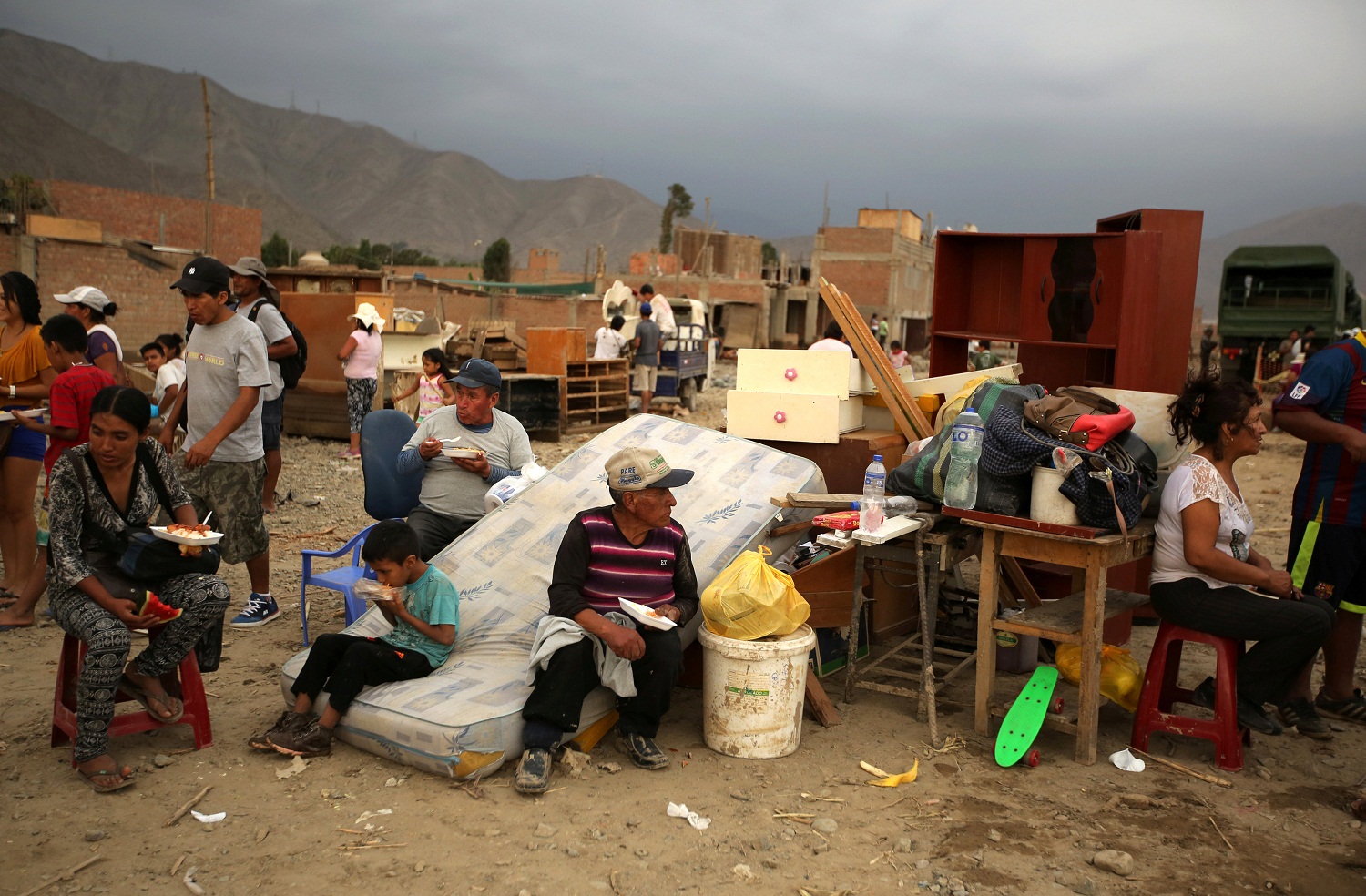 Residents rest next to their belongings, after rivers breached their banks due to torrential rains, causing flooding and widespread destruction in Huachipa, Lima, Peru, March 18, 2017. REUTERS/Mariana Bazo