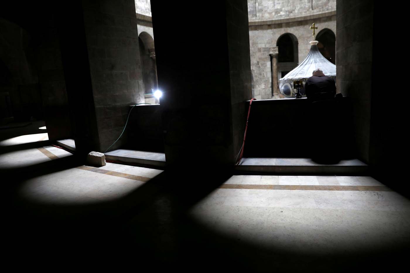 A priest looks down towards the newly restored Edicule, the ancient structure housing the tomb, which according to Christian belief is where Jesus's body was anointed and buried, at the Church of the Holy Sepulchre in Jerusalem's Old City March 20, 2017. REUTERS/Ronen Zvulun
