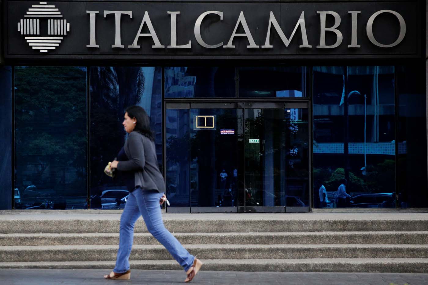 A woman walks past a branch of Italcambio currency exchange in Caracas, Venezuela February 14, 2017. Picture taken February 14, 2017. REUTERS/Marco Bello To match Exclusive VENEZUELA-BANKS/