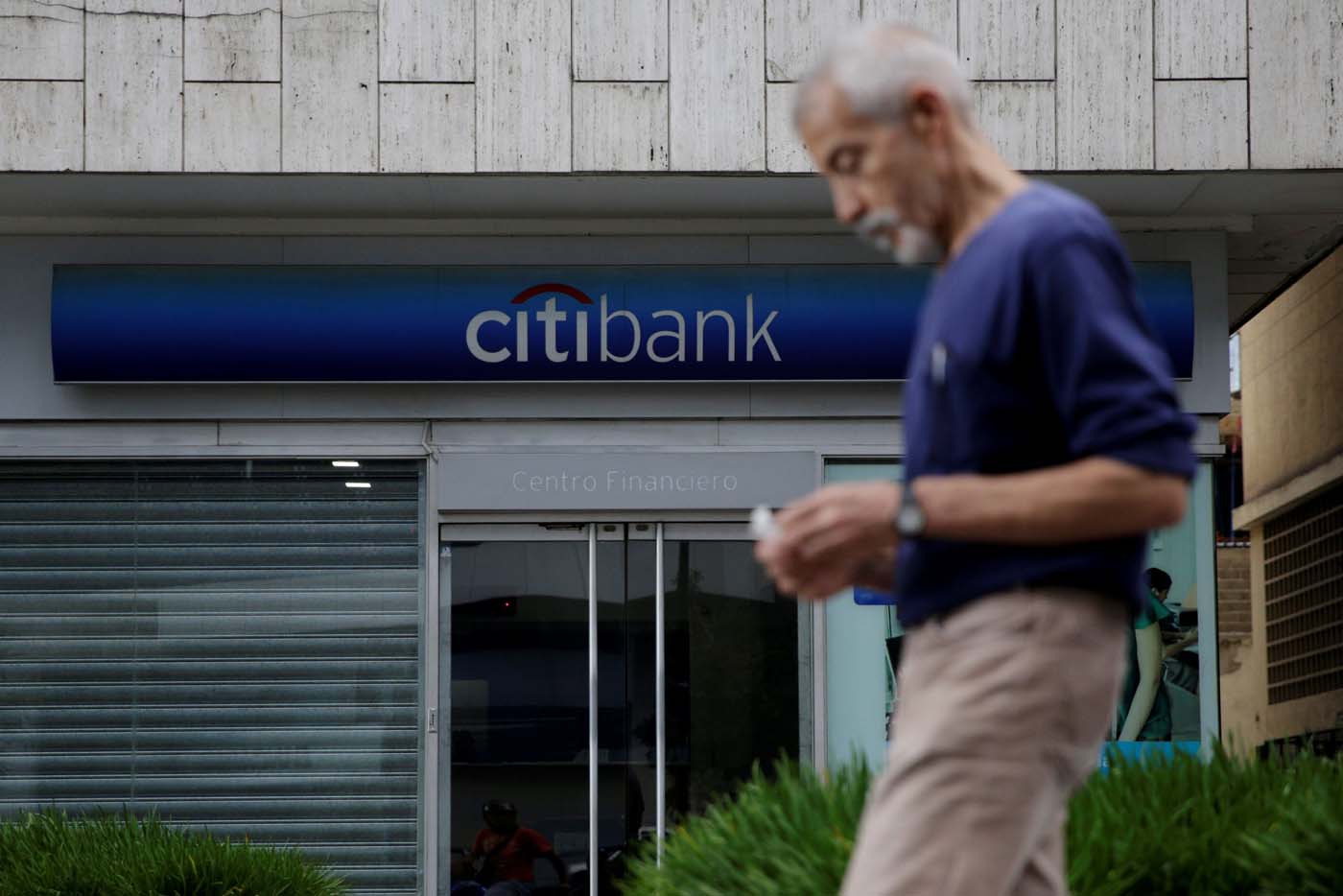 A man walks past a branch of Citi Bank in Caracas, Venezuela February 14, 2017. Picture taken February 14, 2017. REUTERS/Marco Bello To match Exclusive VENEZUELA-BANKS/