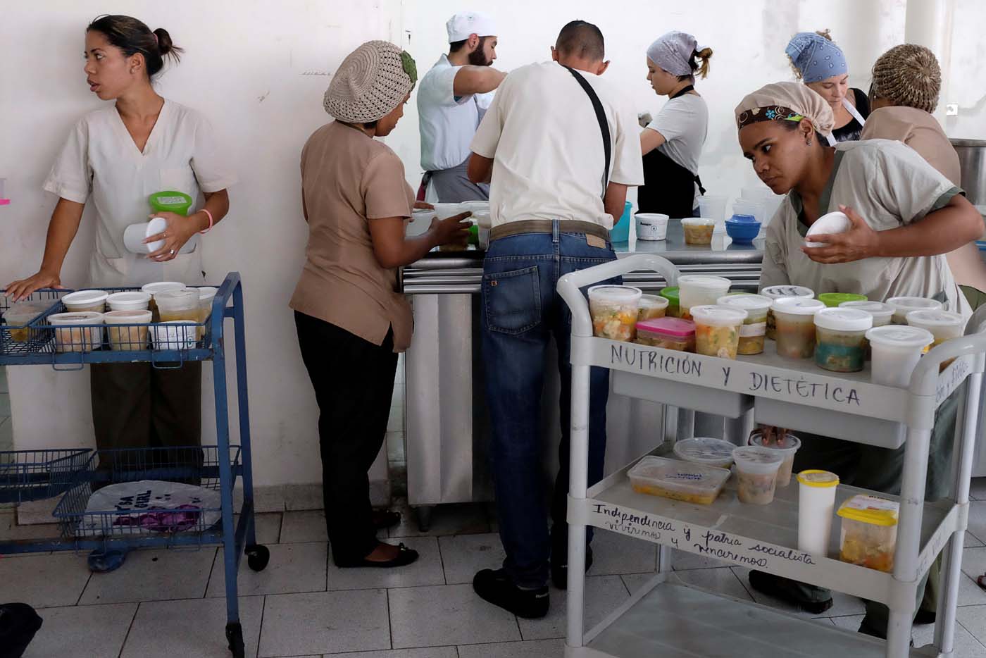 Waitresses of the J.M. de los Rios Children Hospital wait for cups of soup donated by La Casa Bistro restaurant, member of the "Full Stomach, Happy Heart" (Barriga llena, corazon contento) charity, to distribute them at hospitalization floors, in Caracas, Venezuela February 20, 2017. Picture taken February 20, 2017. REUTERS/Marco Bello