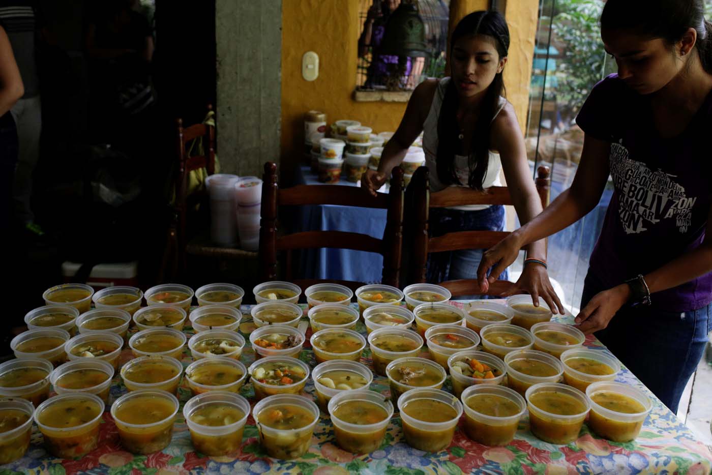 Volunteers of the Make The Difference (Haz La Diferencia) charity initiative serve cups of soup to be donated, at the home kitchen of one of the volunteers in Caracas, Venezuela March 5, 2017. Picture taken March 5, 2017. REUTERS/Marco Bello