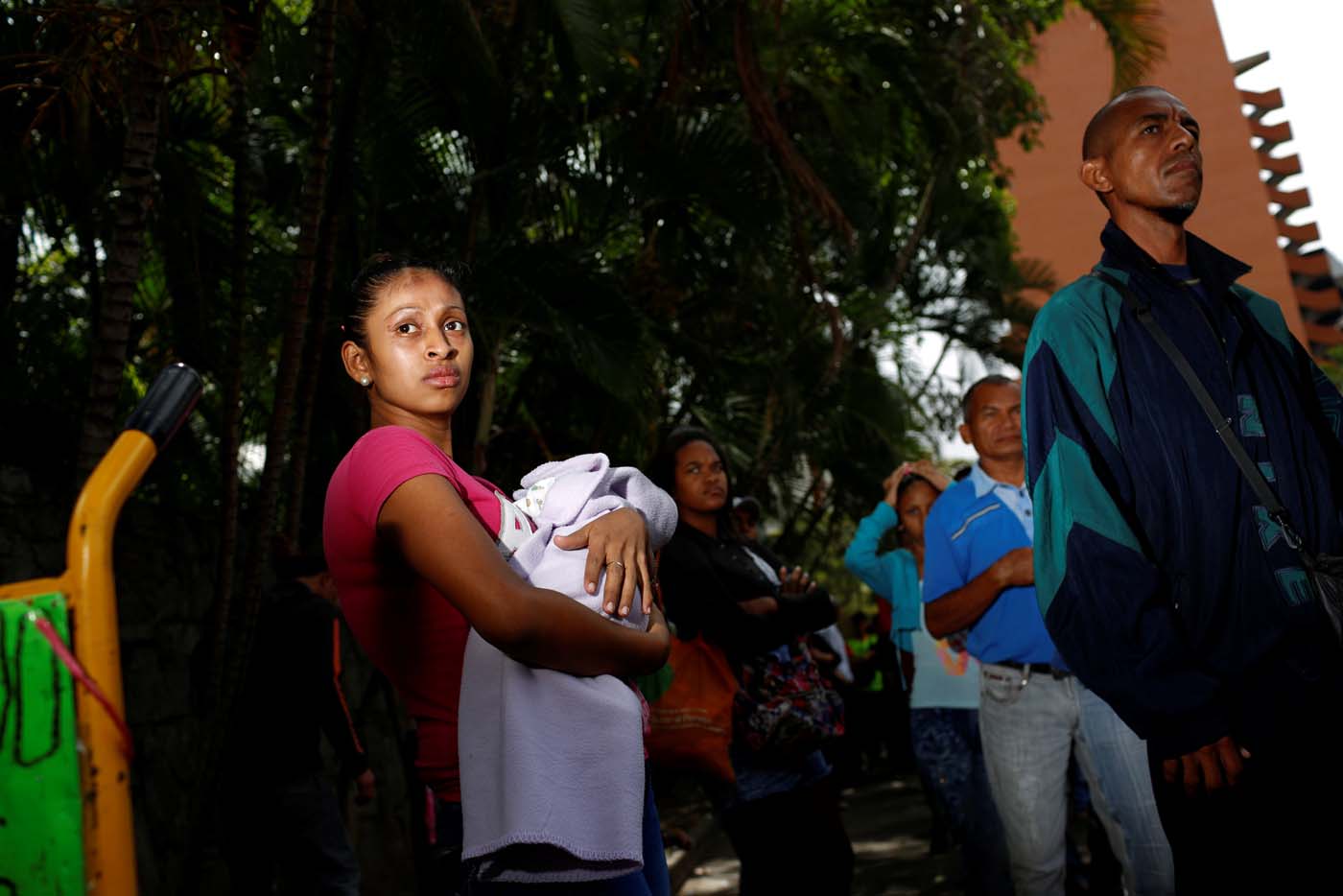 A woman carrying a baby queues as she trys to buy food outside a supermarket in Caracas, Venezuela March 10, 2017. REUTERS/Carlos Garcia Rawlins SEARCH "GARCIA QUEUEING" FOR THIS STORY. SEARCH "WIDER IMAGE" FOR ALL STORIES.