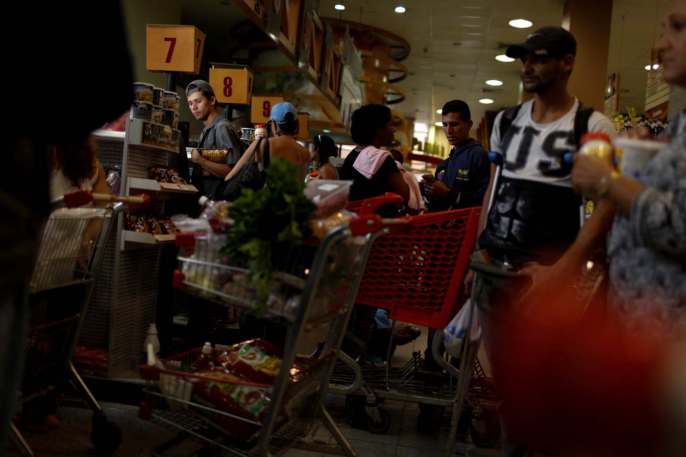 A man waits in line to pay for food at the cashier of a supermarket in Caracas, Venezuela March 10, 2017. REUTERS/Carlos Garcia Rawlins SEARCH "GARCIA QUEUEING" FOR THIS STORY. SEARCH "WIDER IMAGE" FOR ALL STORIES.